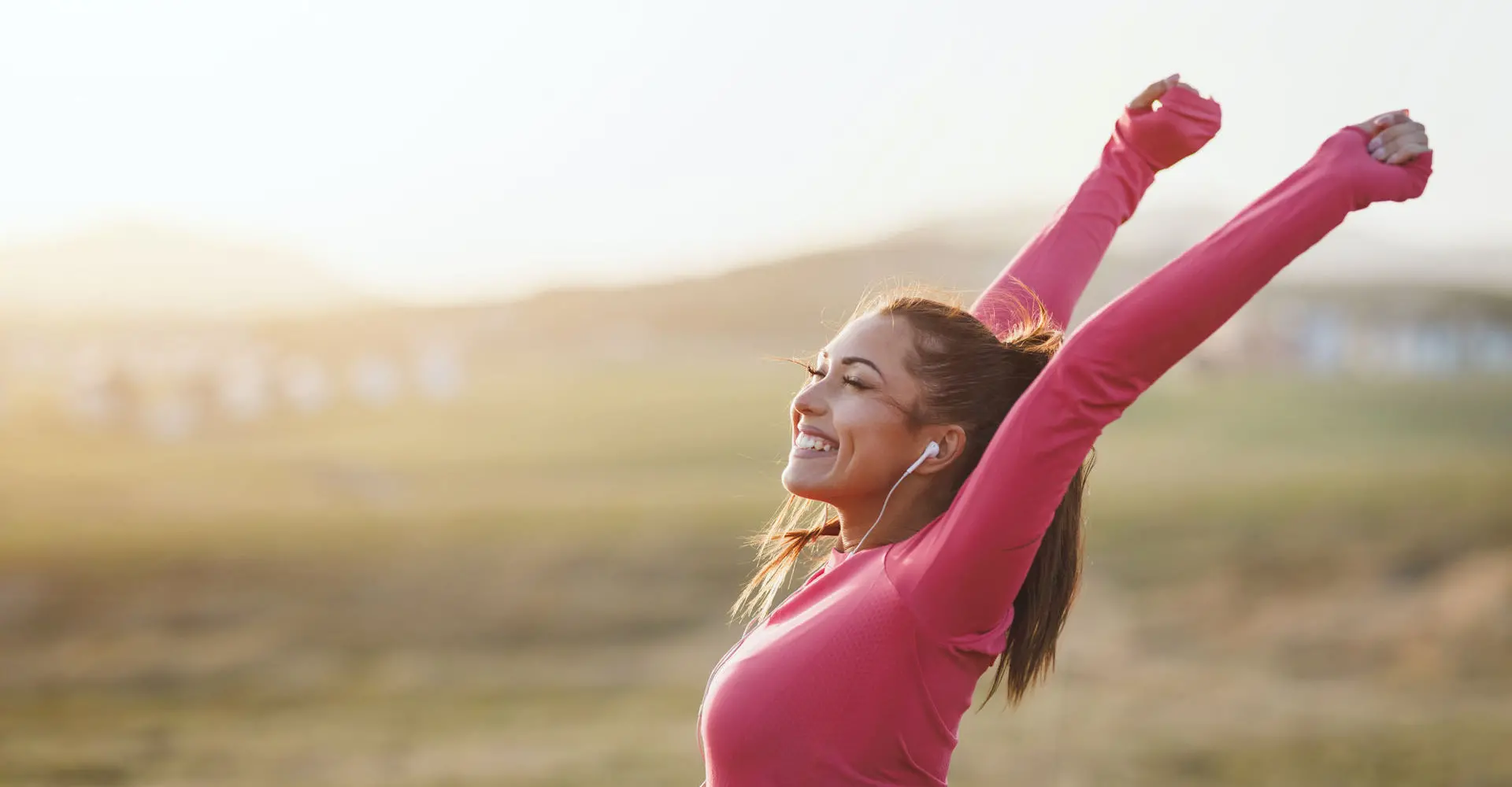 woman smiling arms raised