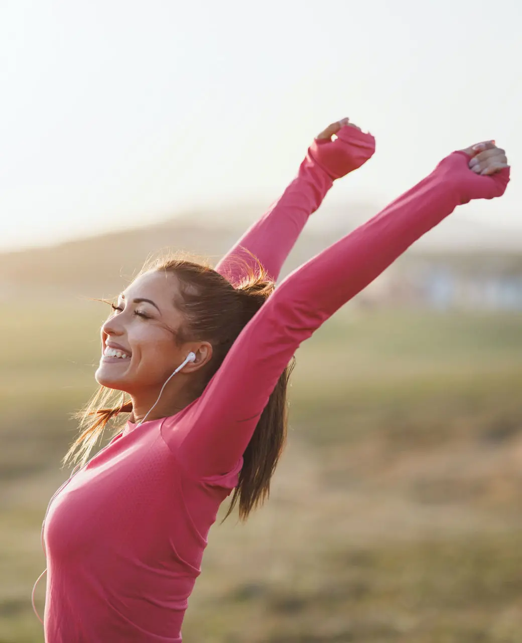 woman smiling arms raised